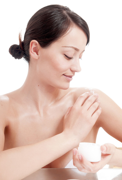 Beautiful woman applying cosmetic cream treatment on her body - Foto, Bild