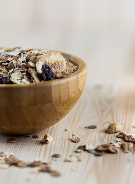 Muesli and granola in blurred wooden background. (Shallow aperture intended for  the aesthetic quality of the blur.) - Fotó, kép