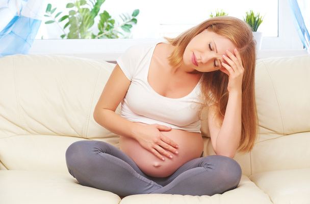 zwangere vrouw met hoofdpijn en pijn - Foto, afbeelding