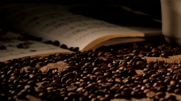 Coffee beans and music on sacking, black background - Footage, Video