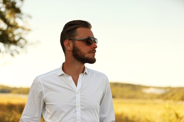 Attractive man standing outside a field - 写真・画像