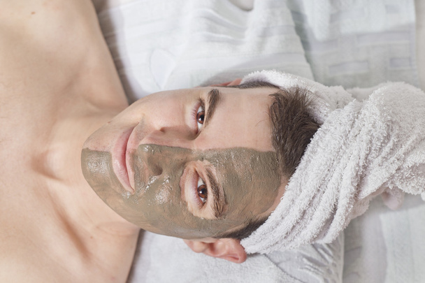 relaxing man with a mud mask on this face - Photo, Image