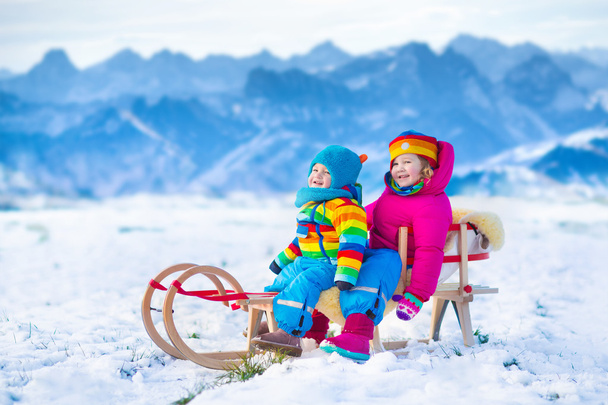 そりで戯れる子供たちが雪に乗る - 写真・画像