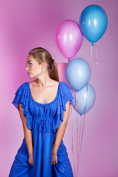 Fashion portrait of beautiful woman in blue dress posing in stud - Фото, изображение