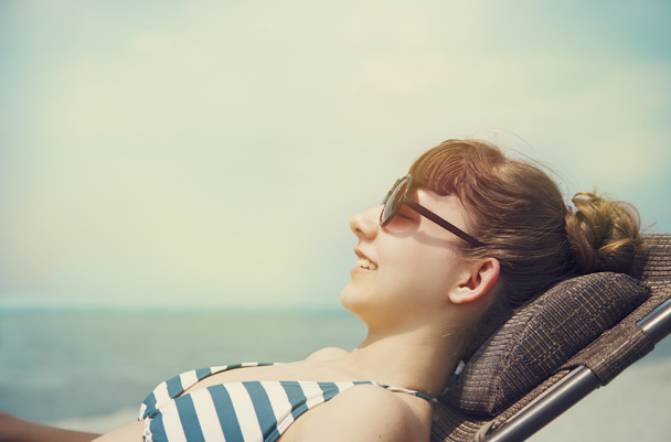 Krásná dívka, relaxační a usmívá se na letní beach. - Fotografie, Obrázek