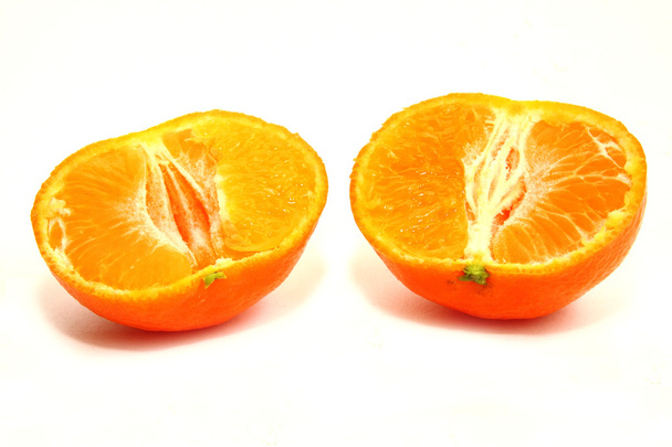 Dos mitades de una mandarina sobre fondo blanco
 - Foto, Imagen