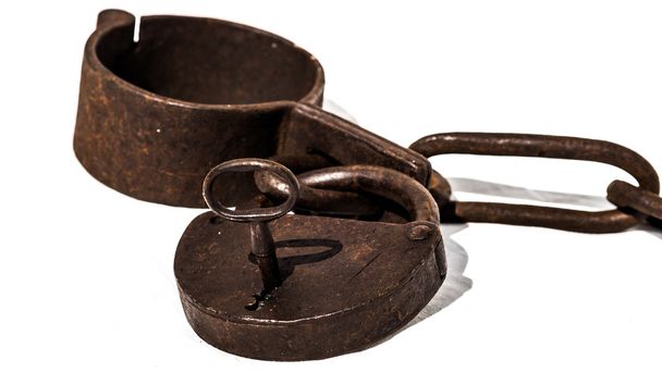 Correntes velhas, ou grilhões, com cadeado e chave utilizados para travar u
 - Foto, Imagem