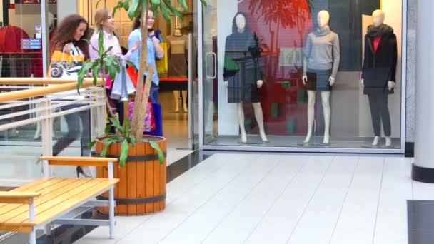 Τρία όμορφα κορίτσια με σακούλες για ψώνια πηγαίνει στο εμπορικό κέντρο - Πλάνα, βίντεο