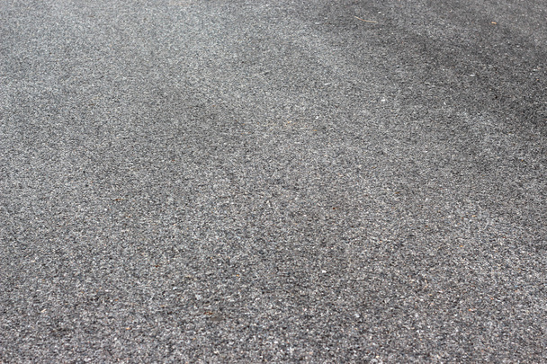 Asfalto de calle mojada con rocas y textura áspera
 - Foto, Imagen