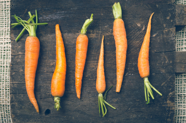 all-natural carrots lined up on wooden board rustic concept - 写真・画像