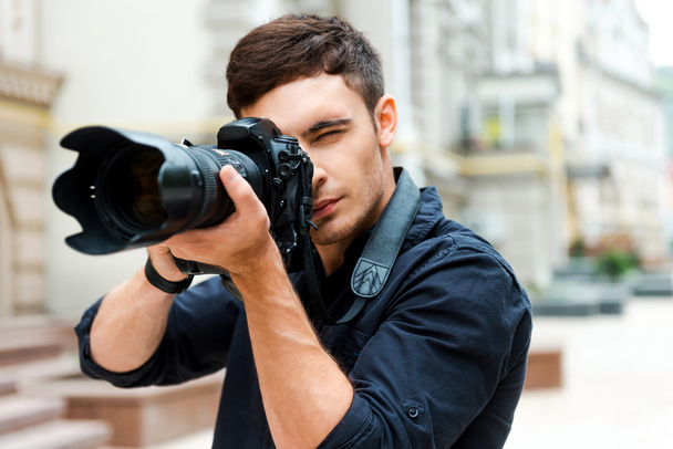 young man photographing something - Foto, afbeelding