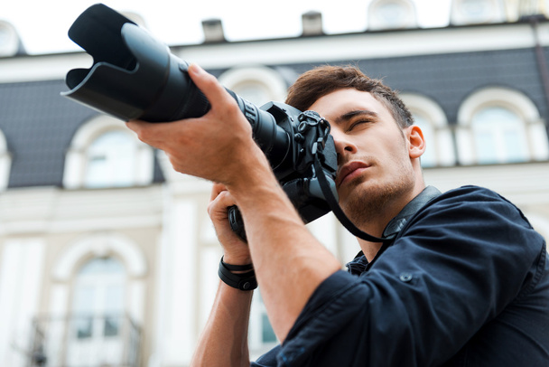 young man photographing something - Φωτογραφία, εικόνα