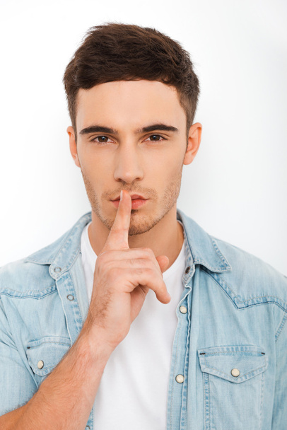 young man holding finger on lips - Photo, image