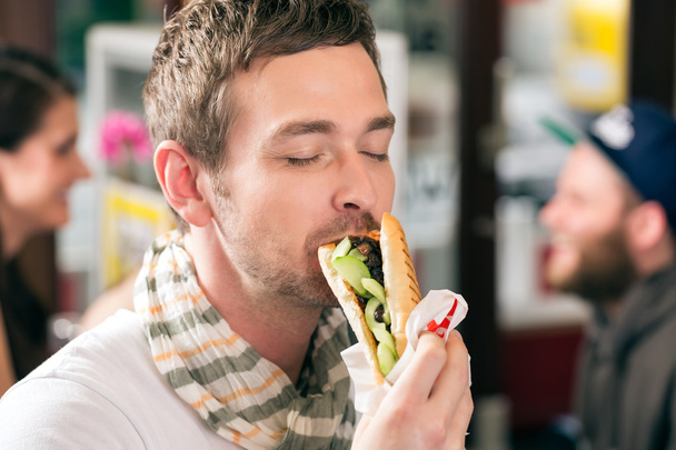 Cliente comiendo Hotdog en snack bar de comida rápida
 - Foto, imagen