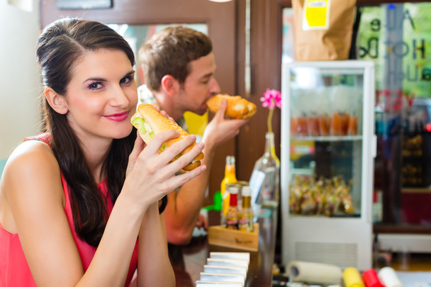 Les clients mangent Hotdog dans le snack-bar fast food
 - Photo, image