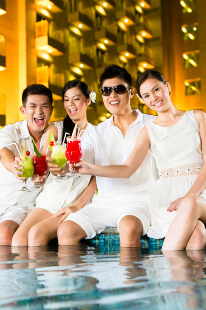 Kiinalaiset parit juovat cocktaileja hotellin allasbaarissa
 - Valokuva, kuva