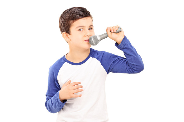Joyful little kid singing on a microphone - Foto, imagen