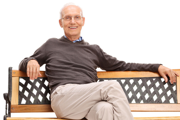senior man sitting on a wooden bench - Foto, afbeelding