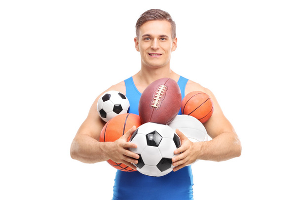 Young athlete holding a bunch of different balls - Photo, Image