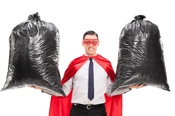 superhero holding two trash bags - Foto, Bild