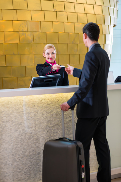 Hotel receptioniste inchecken man die geeft key-card - Foto, afbeelding