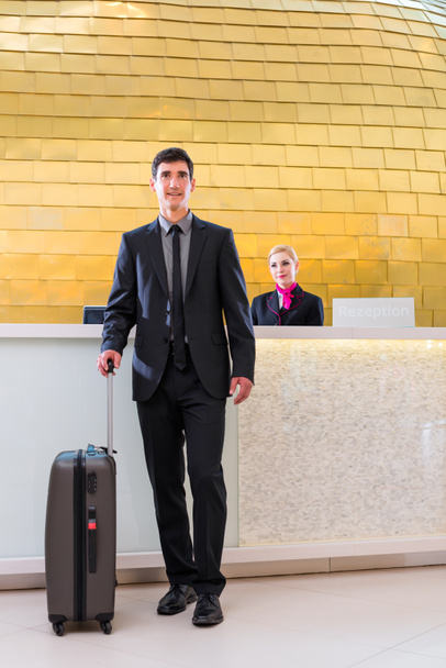 Hombre que sale de viaje de negocios en la recepción del hotel
 - Foto, Imagen