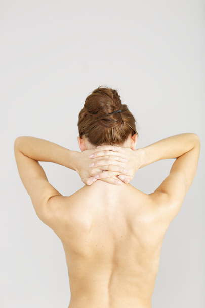 woman facing away massaging her neck - Фото, изображение
