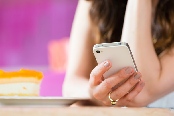 Jeune femme dans le salon de crème glacée avec textos de téléphone
 - Photo, image