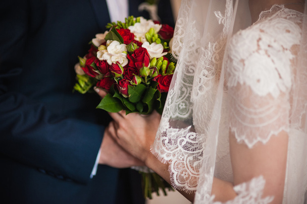 Bride and groom holding bridal bouquet  - Фото, изображение