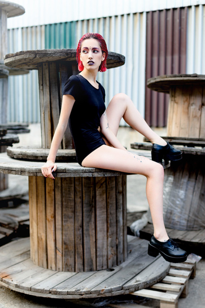 Attractive young woman on wooden reels - 写真・画像