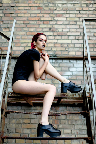 Attractive woman posing on metal stairs - Fotó, kép