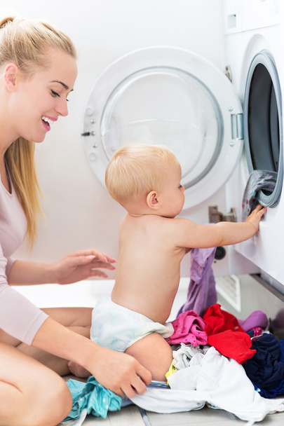 Mother and baby loading clothes - Foto, Imagen