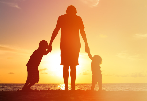 isä ja kaksi lasta kävelemässä auringonlaskun aikaan
 - Valokuva, kuva