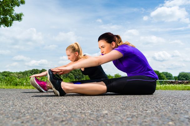jonge vrouwen doen fitness in park - Foto, afbeelding