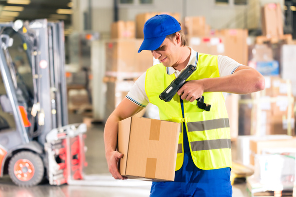 worker scans package in warehouse of forwarding - Fotoğraf, Görsel