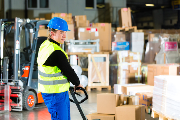 Storeman with mover at warehouse of forwarding - Foto, afbeelding