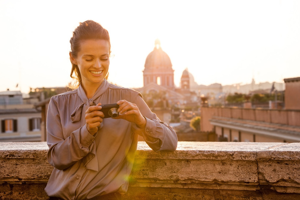 Smiling elegant woman checking photos on camera in Rome - Foto, imagen