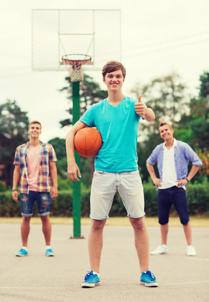group of smiling teenagers playing basketball - Foto, Imagen