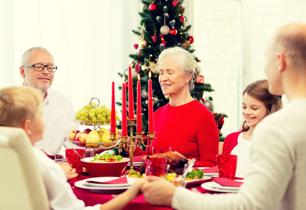 smiling family having holiday dinner at home - Fotografie, Obrázek