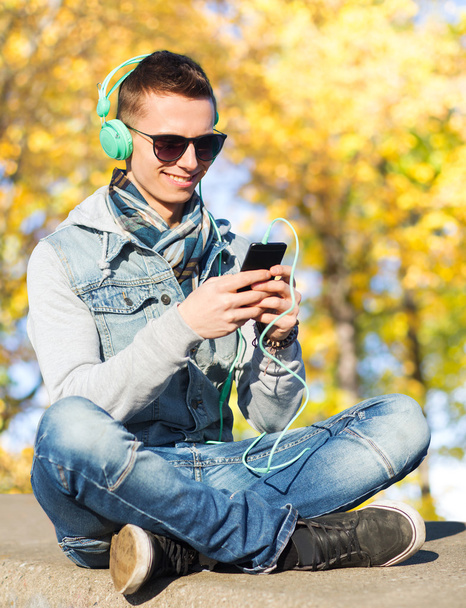 happy young man in headphones with smartphone - Photo, image