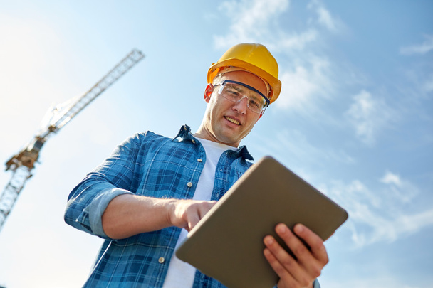 builder in hardhat with tablet pc at construction - Photo, image
