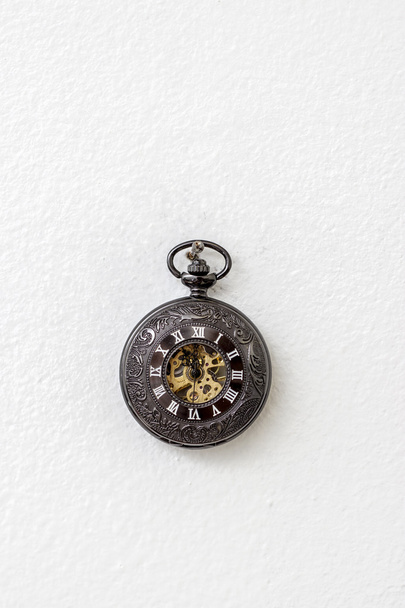 Old pocket watch hanging on the white wall - Foto, Imagen
