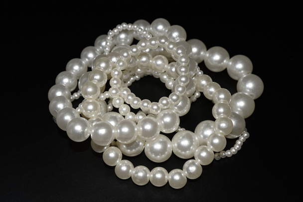 pulseras de perlas sobre fondo negro
 - Foto, imagen