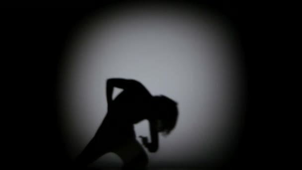 Extraordinary moves in shadow of contemporary dancer on black background, spot light - Filmati, video