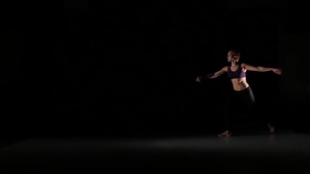 Beautiful girl dancing contemp in the shadow on black background, slow motion - Imágenes, Vídeo