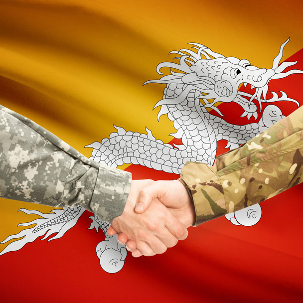 Чоловіки у військовій формі, потискує руку прапор на фоні - Бутан - Фото, зображення