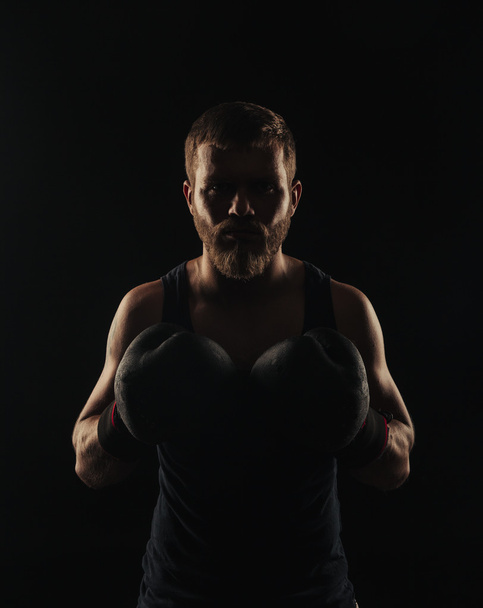 Boxeador atlético barbudo con guantes sobre fondo oscuro
 - Foto, Imagen