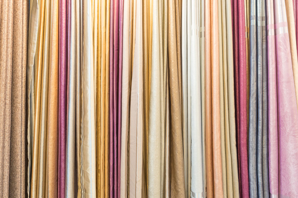 Colorful curtain samples hanging from hangers on a rail in a dis - Фото, изображение