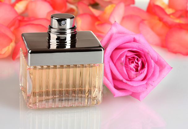 Perfume in a beautiful bottle, petals and pink rose isolated on white - Фото, зображення