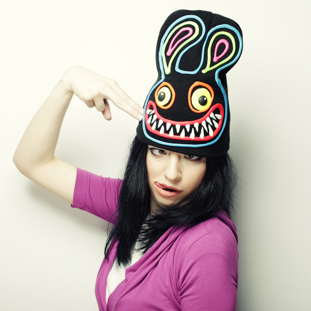 Playful young woman in funny hat with rabbit - Fotó, kép